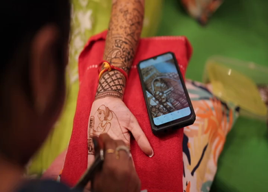 A Slow Motion Shot of a girl getting Mehndi applied on her hand at an Indian Wedding
