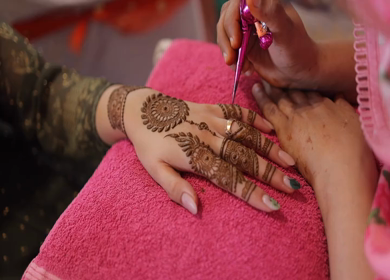 A Slow Motion Shot of a girl getting Mehndi applied on her hand at an Indian Wedding