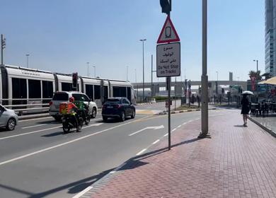 30 March 2023 : A Pan Shot of a Dubai Tram Crossing Road at Jumeirah Beach Residence- JBR  at Dubai,UAE 