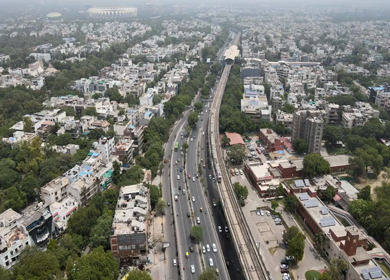 An aerial shot of the Delhi Metro moving in New Delhi, India