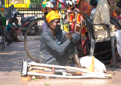 A close up shot of a disabled man outside Hanuman Mandir