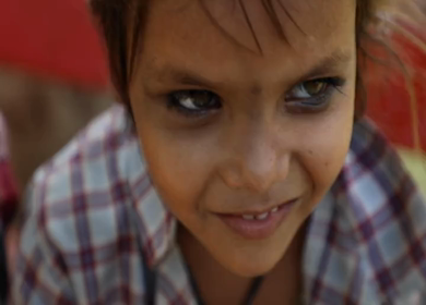 A shot of a cute kid sitting at Leh city during the day time at Ladakh