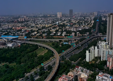 A rotating aerial hyperlapse shot of the Delhi Metro and Traffic movement at Noida,NCR,India