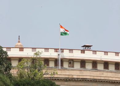 A static shot of the Parliament House and Indias national flag in New Delhi, India