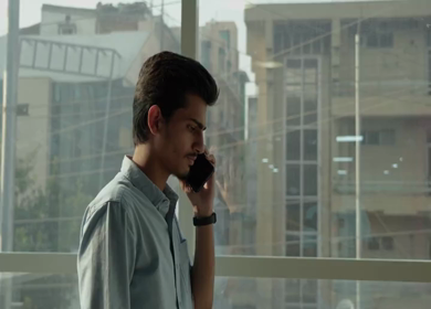 A Shot of an Indian Boy doing work discussion over a phone call in office